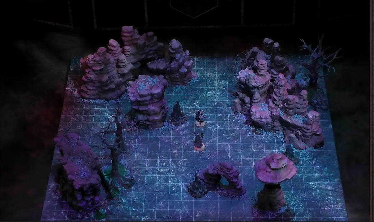 A battlemap of a flat area with various tall natural rocky towers and leafless trees. Fearne faces off against Dark Fearne while Orym watches from a distance behind a tree.