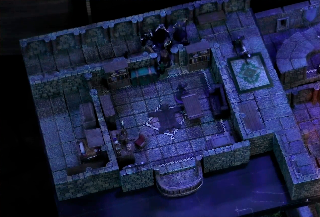 A battlemap of a stone palace upper floor. Occtis stands next to a wooden table in a room with a bearskin rug, balcony, cluttered desk, bench, and shelves. A number of robed individuals including Ethrand Tachonis stand outside the room, down the hall from a fallen guard. Aranessa stands in the room, facing the group of intruders.