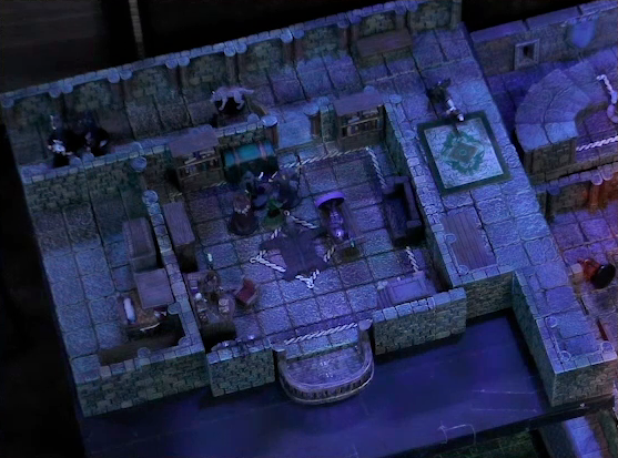 A battlemap of a stone palace upper floor. Occtis lays on a wooden table in a small room with a bearskin rug and balcony. A number of robed individuals are nearby fighting Aranessa. Thaisha in wolf form stands outside in the hallway, facing off against more robed individuals. A fallen guard is outside the room, down the hall.