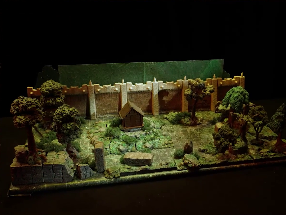 A battlemap of a wooded courtyard bordered on one side by a tall stone defensive wall. A translucent blue magic-looking barrier tops the wall. A small wooden shed sits among some bushes in the center of the courtyard. Filling the rest of the space are trees and old-looking standing stones with circular runic patterns carved into their sides.