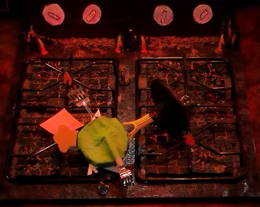 A battlemap that looks like a stovetop. Wok Wok, the giant frying pan creature, lies face-down across the burners. Jessep, Kai, Sky, Padmund, Beau, and Yasha are spread across the rest of the stove. The front right burner has a pink sticky note on it. Small flames sprout from each of the four burners and four knobs are on the back panel. The base of the battlemap looks like magma and the scene is bathed in red light.