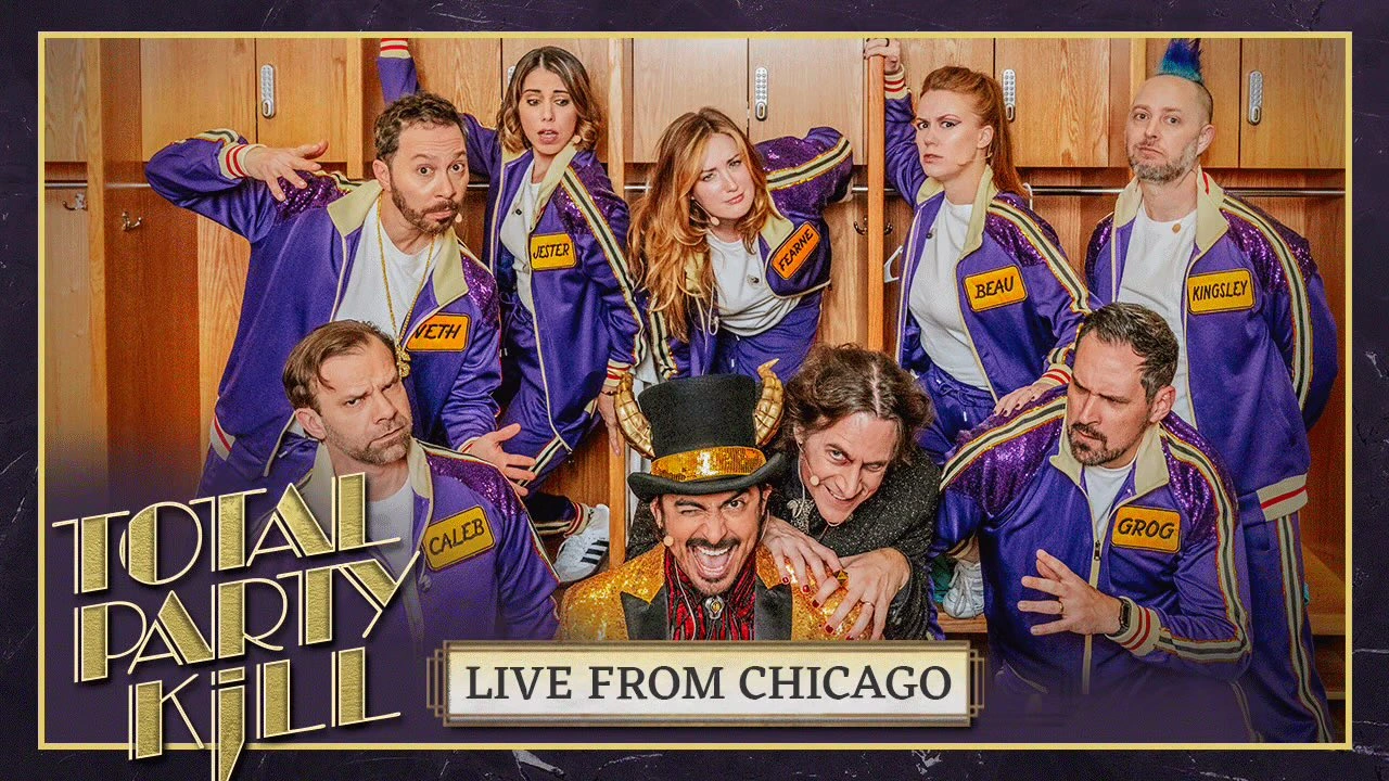 Thumbnail for “TOTAL PARTY KILL: LIVE FROM CHICAGO”. A group photo of Sam, Laura, Ashley, Marisha, Taliesin, Liam, Robbie Daymond, Matt, and Travis posing in front of a wall of wooden lockers. Most of the cast is dressed in purple track suits with name patches reading “CALEB”, “VETH”, “JESTER”, “FEARNE”, “BEAU”, “KINGSLEY”, and “GROG”. They look a mix of confused and scared. Robbie is wearing a golden sequin suit and top hat with horns sprouting from it over a red and black striped shirt and bolo tie. Matt crouches over Robbie’s left shoulder in a smirk of henchman servility, wearing a black sparkly suit. Robbie winks at the camera.